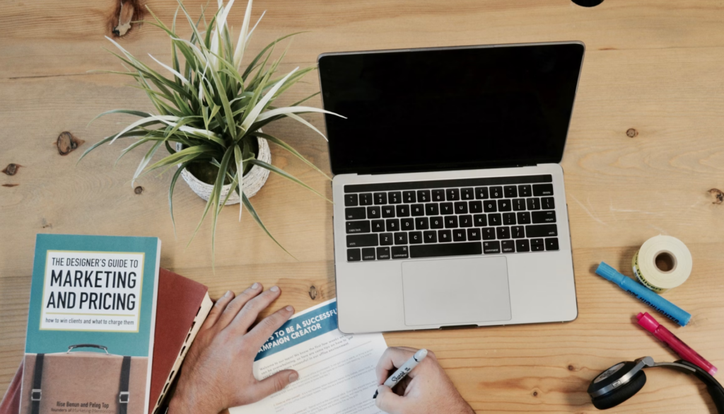 Workspace planning AI content strategy with laptop and marketing resources